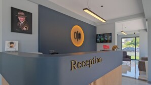 Un mostrador de recepción con diseño moderno, que muestra un logo y la palabra "Reception" en grande.