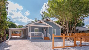 A single-story house with a covered porch, a front entrance, and a fenced yard. - Ultimate 4 Bedroom Comfort So Close to Riverwalk! (San Antonio)