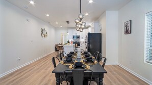 A dining area with a black table set for six, surrounded by chairs. - Ultimate 4 Bedroom Comfort So Close to Riverwalk! (San Antonio)