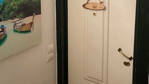 A door with a small wooden sign hanging on it, a light switch, and a door handle. - Portuguese Classic Flat at Lisbon Historic Center (Lisboa)
