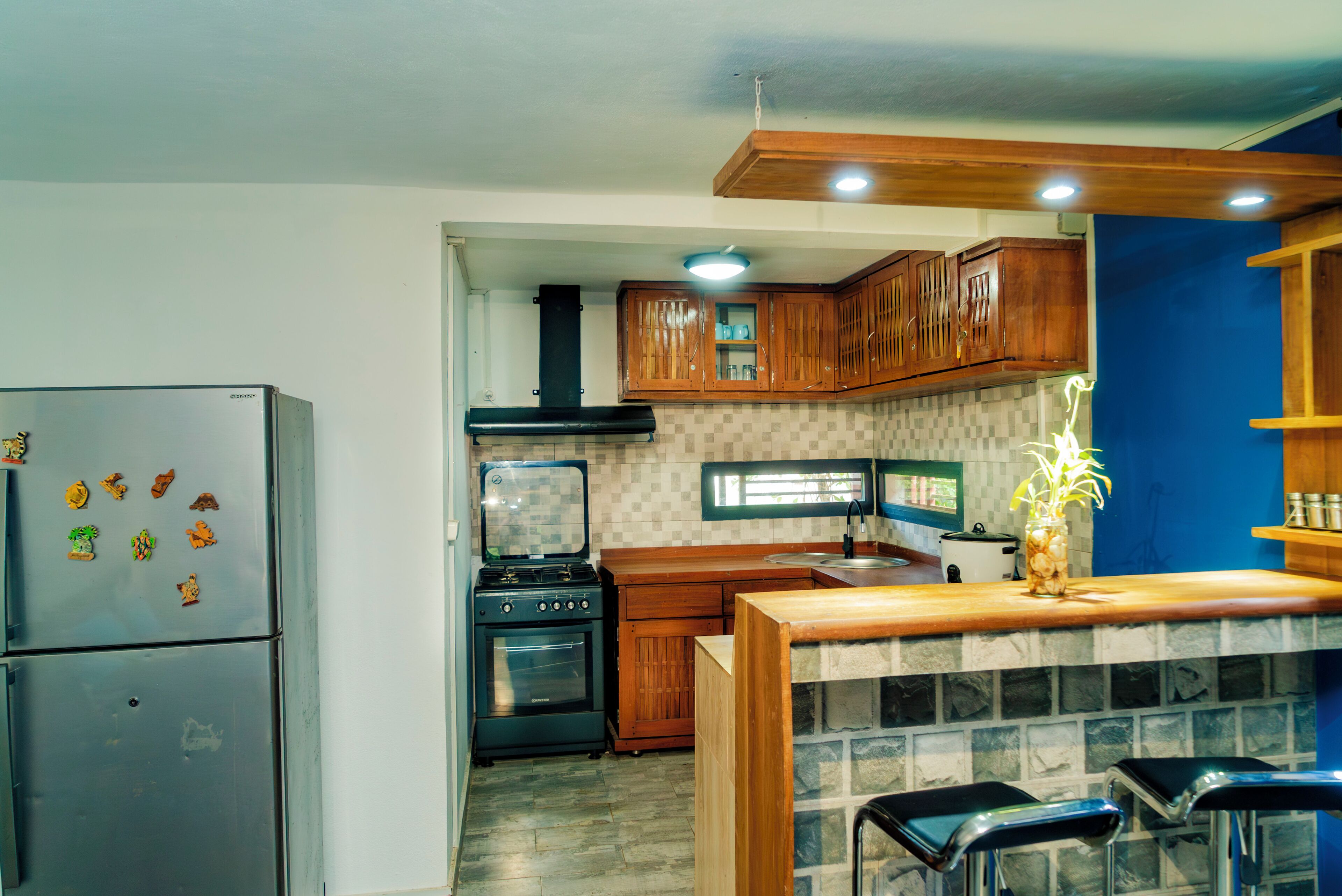A kitchen with wooden cabinets, a refrigerator, a stove, and a sink.