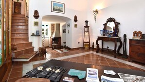 Amplia sala de estar con chimenea, muebles de madera y una escalera.