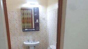 Un baño pequeño con inodoro, lavamanos y espejo.