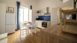 Een moderne keuken met witte kastjes, een houten aanrechtblad en een ingebouwde kookplaat.