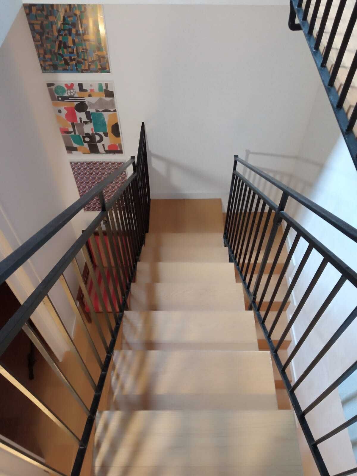 Una escalera con barandillas negras que conduce a una plataforma.