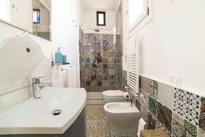 Chuveiro, secador de cabelo, bidê, toalhas de banho