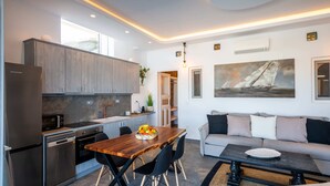 Une cuisine moderne avec un coin repas, un canapé et un tableau au mur.