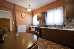 Una cocina con gabinetes de madera, una estufa y una mesa de comedor con sillas.