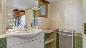 A bathroom with a sink, mirror, towel rack, and a window with a wooden frame. - Bed and Breakfast 'Chambre Double Carpediem Bergerac' with Shared Garden, Wi-Fi and Air Conditioning (Prigonrieux)