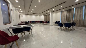 A conference room with a long table and chairs, large windows with curtains, and a tiled floor. - Hotel AVG Palace (Tijara)