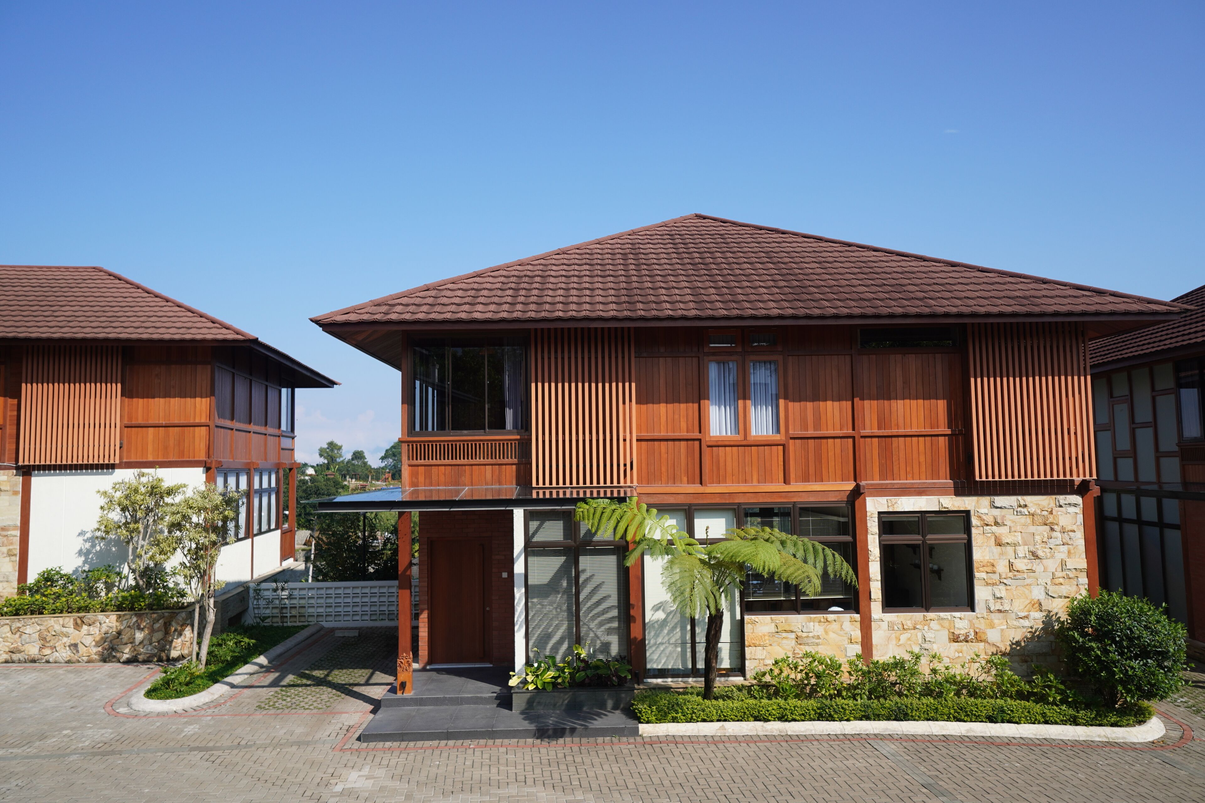 Un bâtiment moderne à deux étages, doté d’une façade en bois et de détails en pierre.