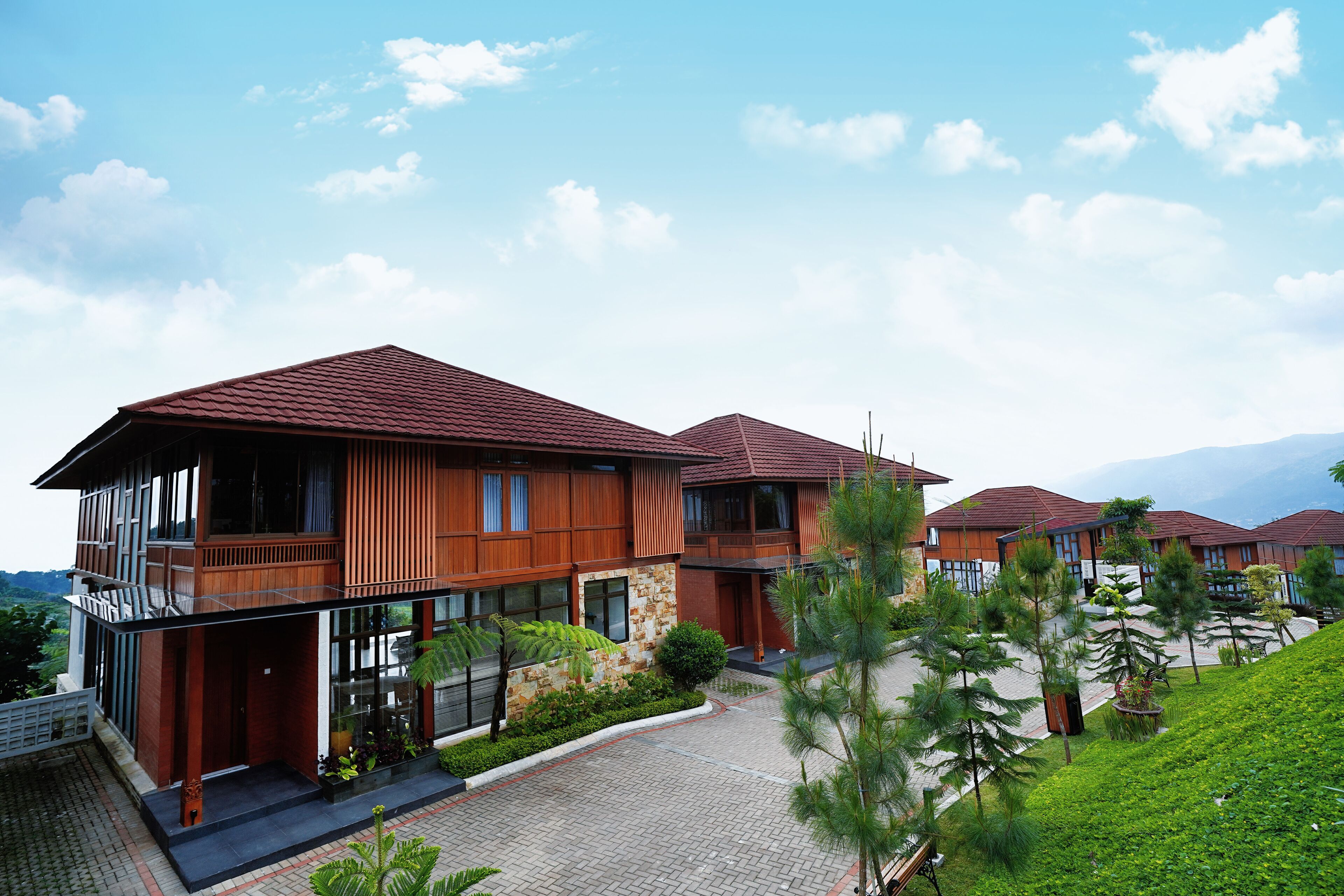 A modern building with multiple levels, large windows, and a red roof.