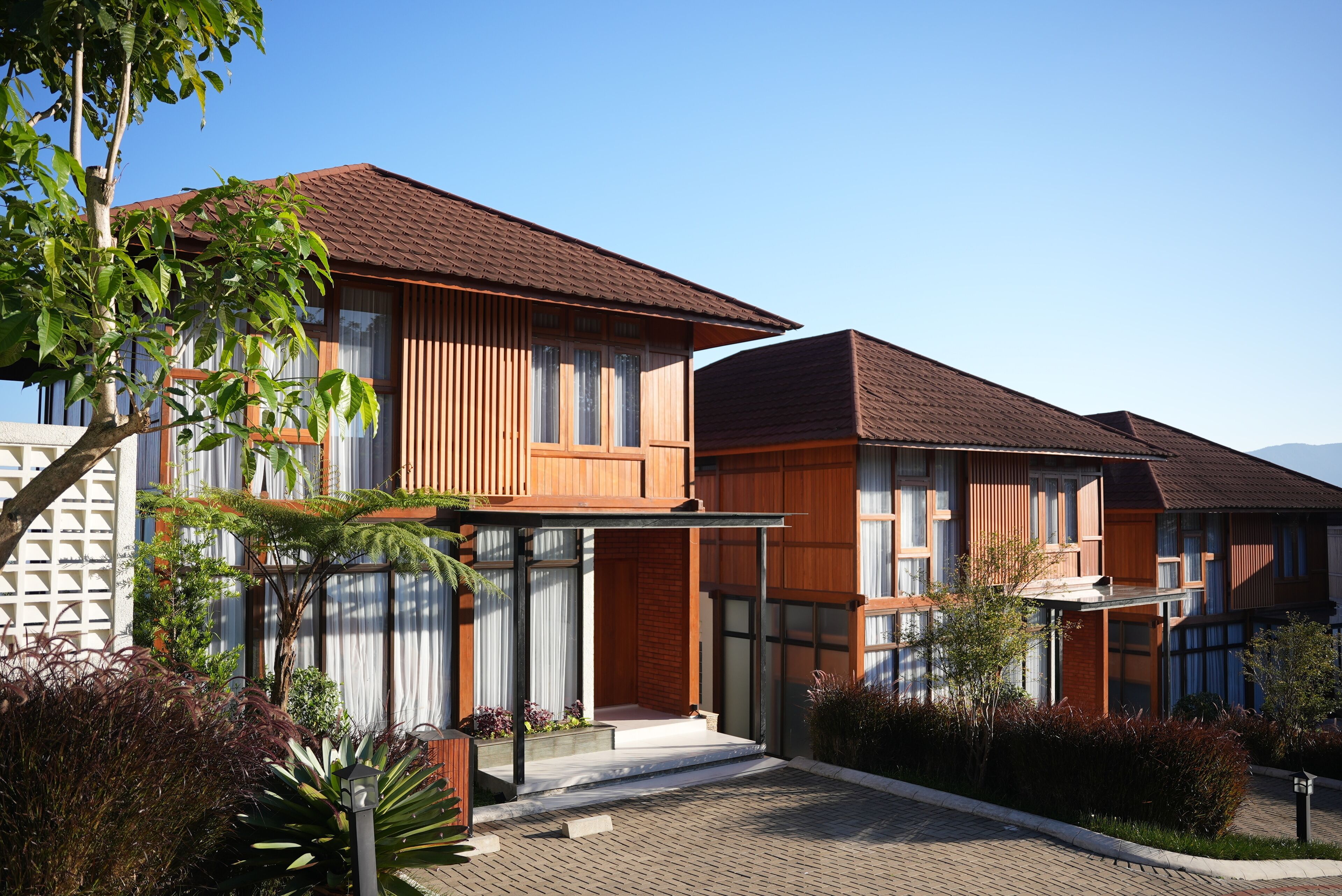 A modern two-story house with a brick facade, large windows, and a covered porch.