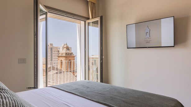 A hotel room with a bed, a large window, and a framed picture on the wall. - Domus Terravecchia  (Agrigento)