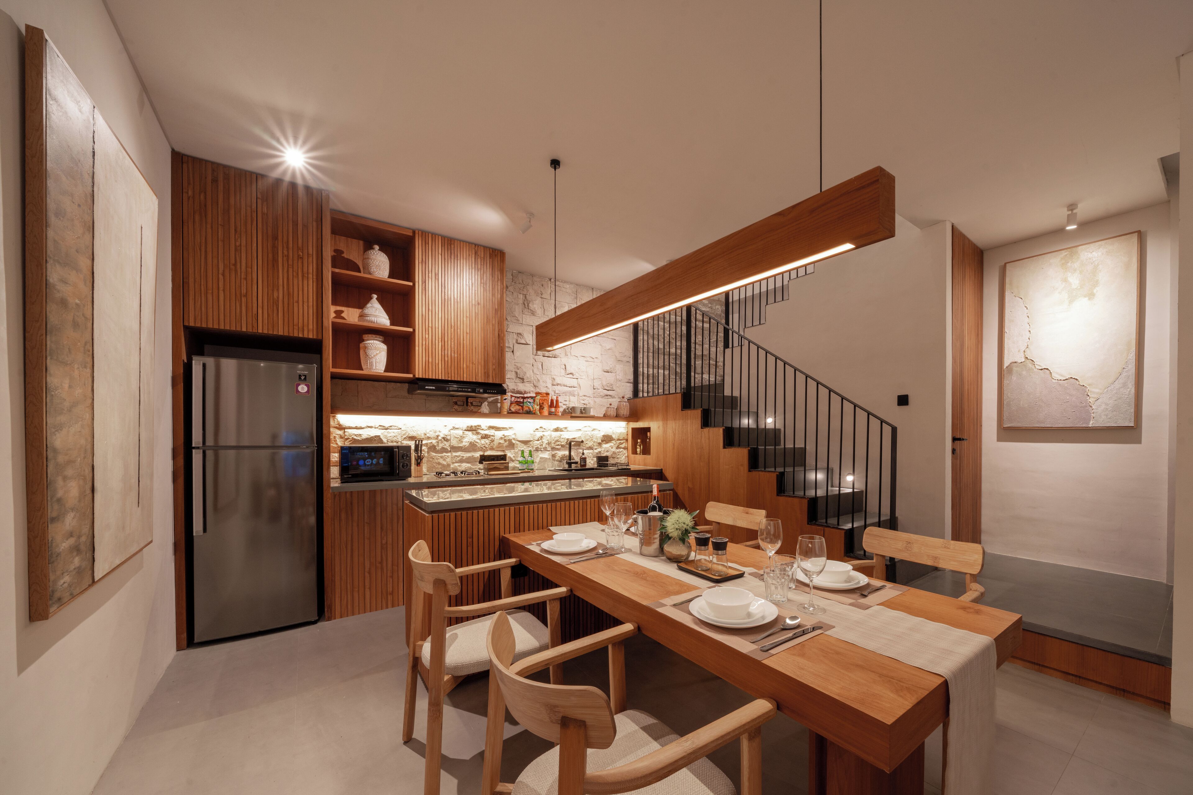 A modern kitchen with wooden cabinets, a built-in island, and a stainless steel refrigerator.