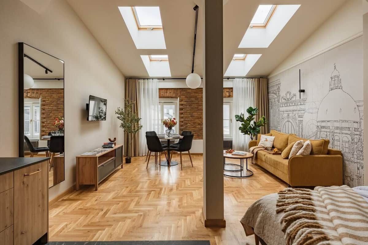 A modern interior with a dining area, sofa, and a bed.