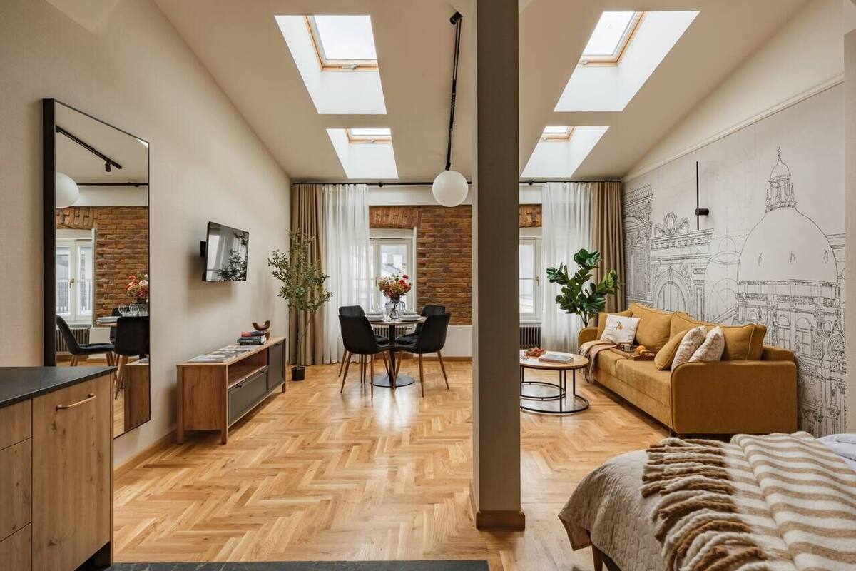 A modern interior with a dining area, sofa, and a bed.