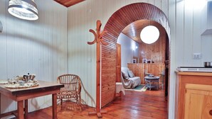 A wooden interior with a dining table, wicker chair, and a cozy seating area with cushions. - GuestHost - Cozy 45 sqm apartment, perfect for 2 people, located on the ground floor of a historic building (1 step to access). A stone's throw from Spaccanapoli (in the restricted traffic zone), the property is ideal for those who want to fully experien (Naples)