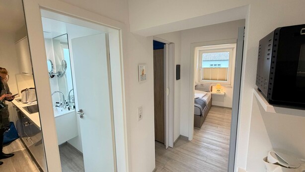 Un apartament modern amb cuina, bany i dormitori.
