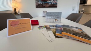Una sala de conferències amb taula blanca, un quadre a la paret i diversos documents.