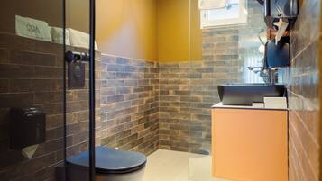 Une salle de bain moderne avec une douche à parois de verre, des toilettes noires et un meuble-lavabo en bois.