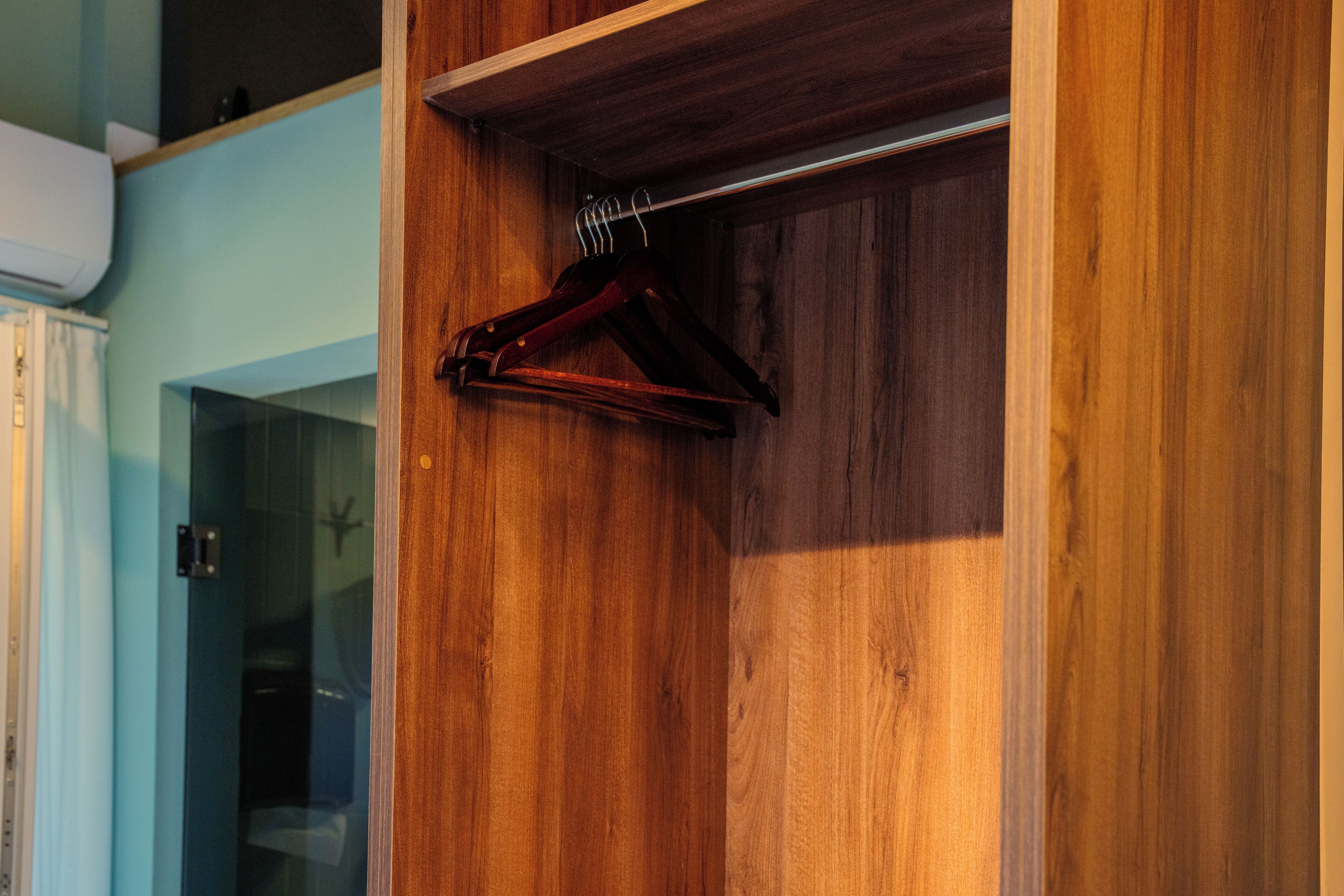 A wooden wardrobe with a hanging rack.