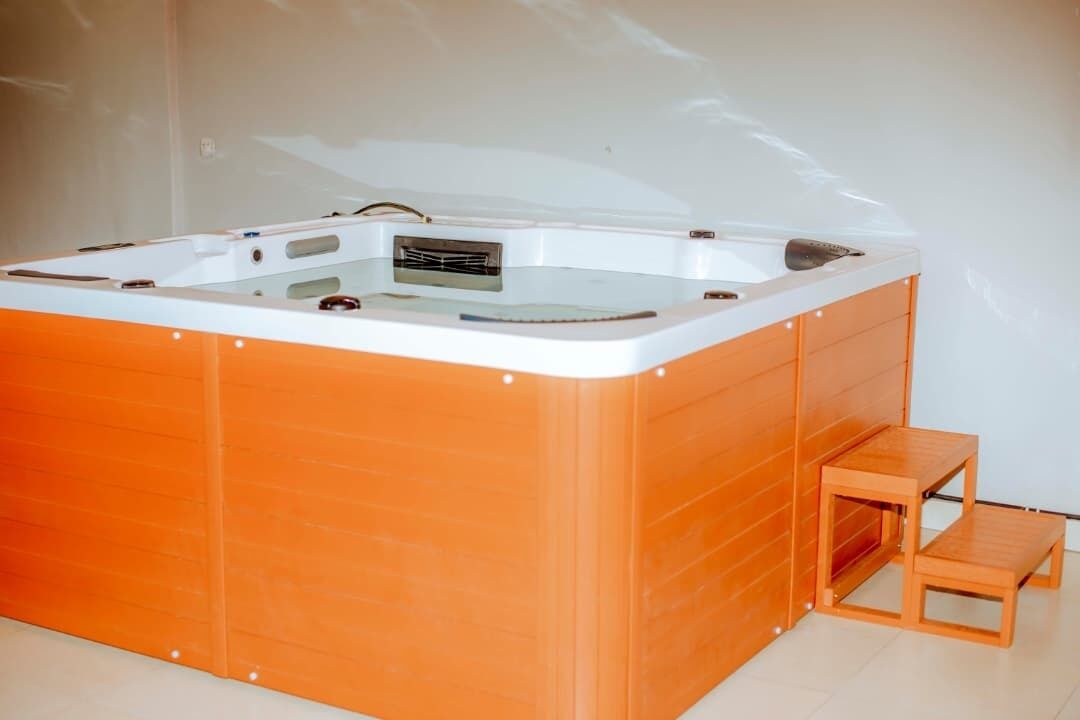 Un jacuzzi con un banco de madera y una pequeña mesa.