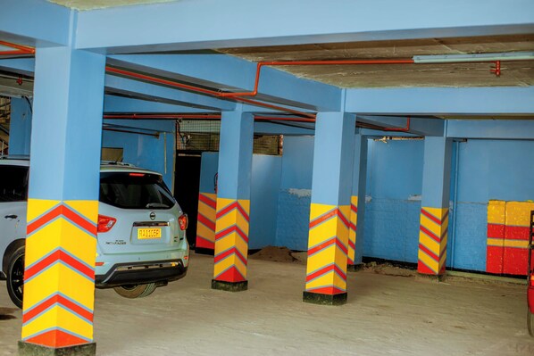 A parking garage with blue walls and pillars featuring chevron patterns. - La Briella Hotel (Gisenyi)