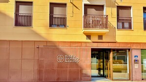 A building with a large metal gate and a sign reading "Museo Damaso Navaarro".