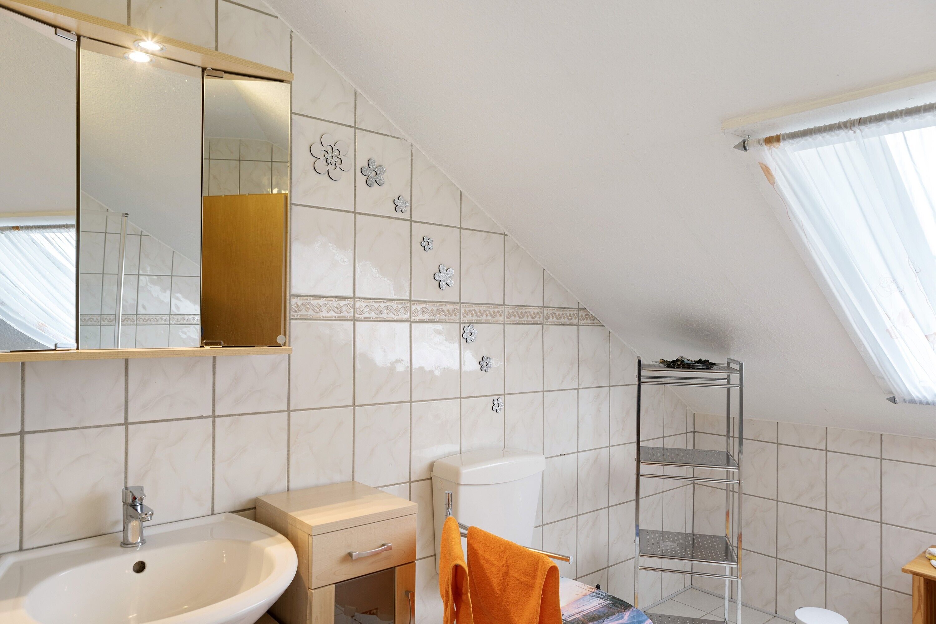 Un baño con lavamanos, espejo, inodoro y zona de ducha.