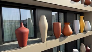 A modern building with multiple floors, each featuring a row of large, uniquely shaped vases displayed on the exterior windowsills. -  Palazzo Le Giare Luxury Apartments (Bari)