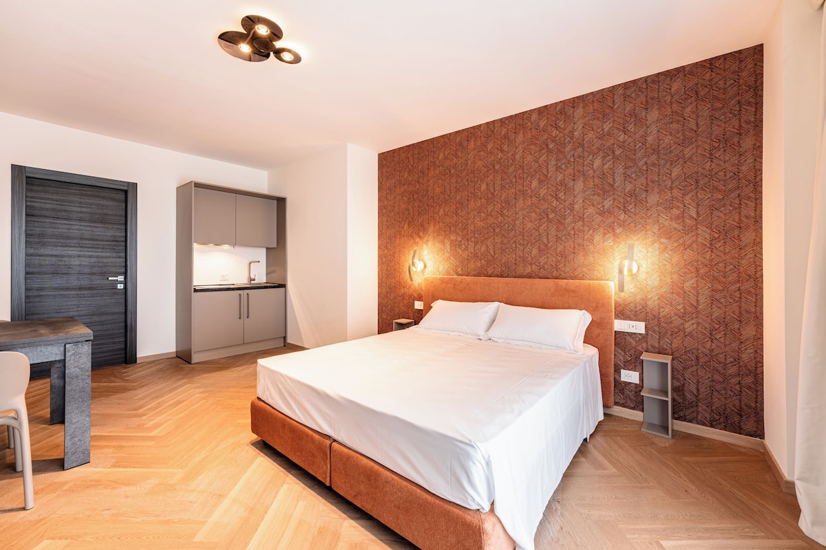 Un dormitorio moderno con una cama grande, un escritorio y un armario.