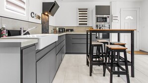 A modern kitchen with a central island, built-in appliances, and a dining area with stools.