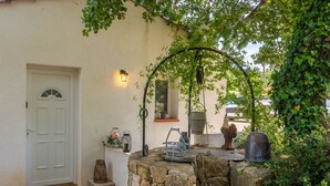 A stone bench with a metal frame, a white door, and a potted plant.