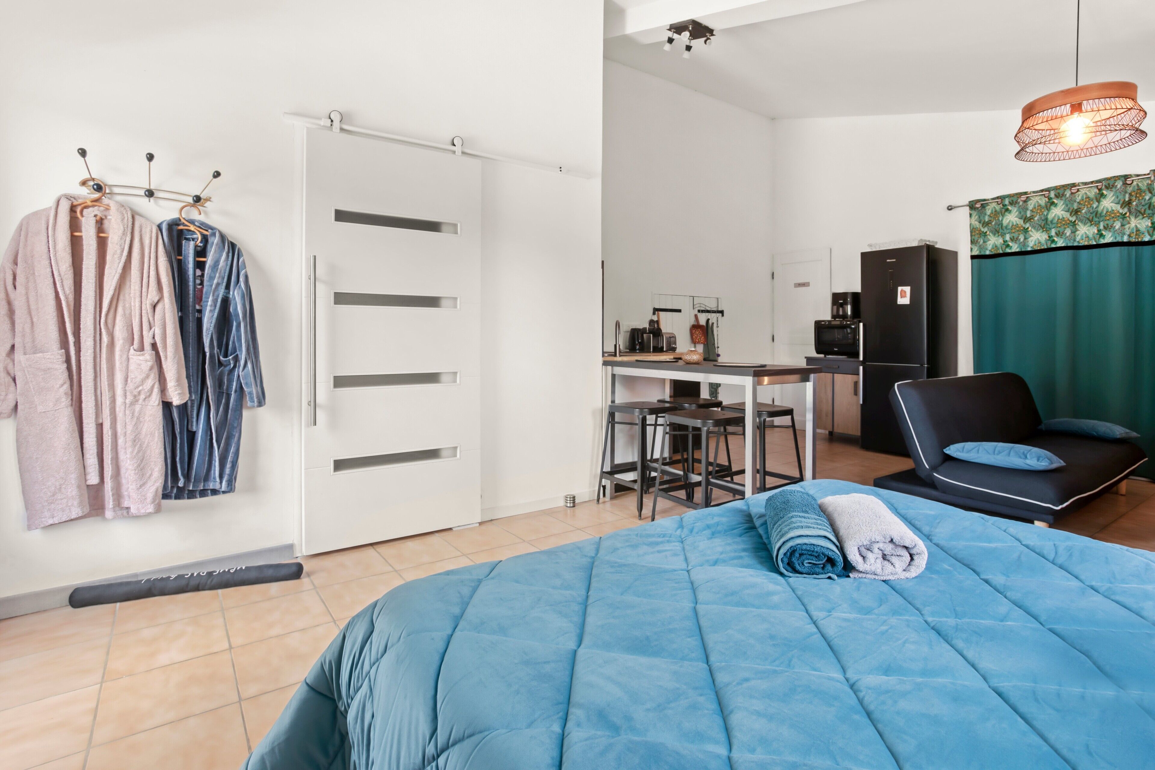 Une chambre à coucher comprenant un lit, un bureau, une chaise, un canapé, une armoire et une salle de bain.