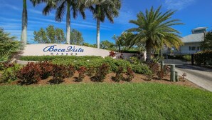 A sign for Boca Vista Harbor with palm trees and well-maintained landscaping.