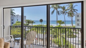 A balcony with a view of the beach and palm trees. - Charming 2 Bedroom Sea Oats - 237 in Boca Grande, perfect for a relaxing getaway. (Boca Grande)