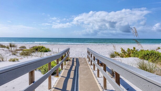 A wooden boardwalk leading to a beach with a clear view of the ocean. - Charming 2 Bedroom Sea Oats - 237 in Boca Grande, perfect for a relaxing getaway. (Boca Grande)