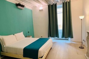 A bedroom with a bed, a nightstand, a floor lamp, and a window with curtains. - Magic of the Spanish Steps (Roma)