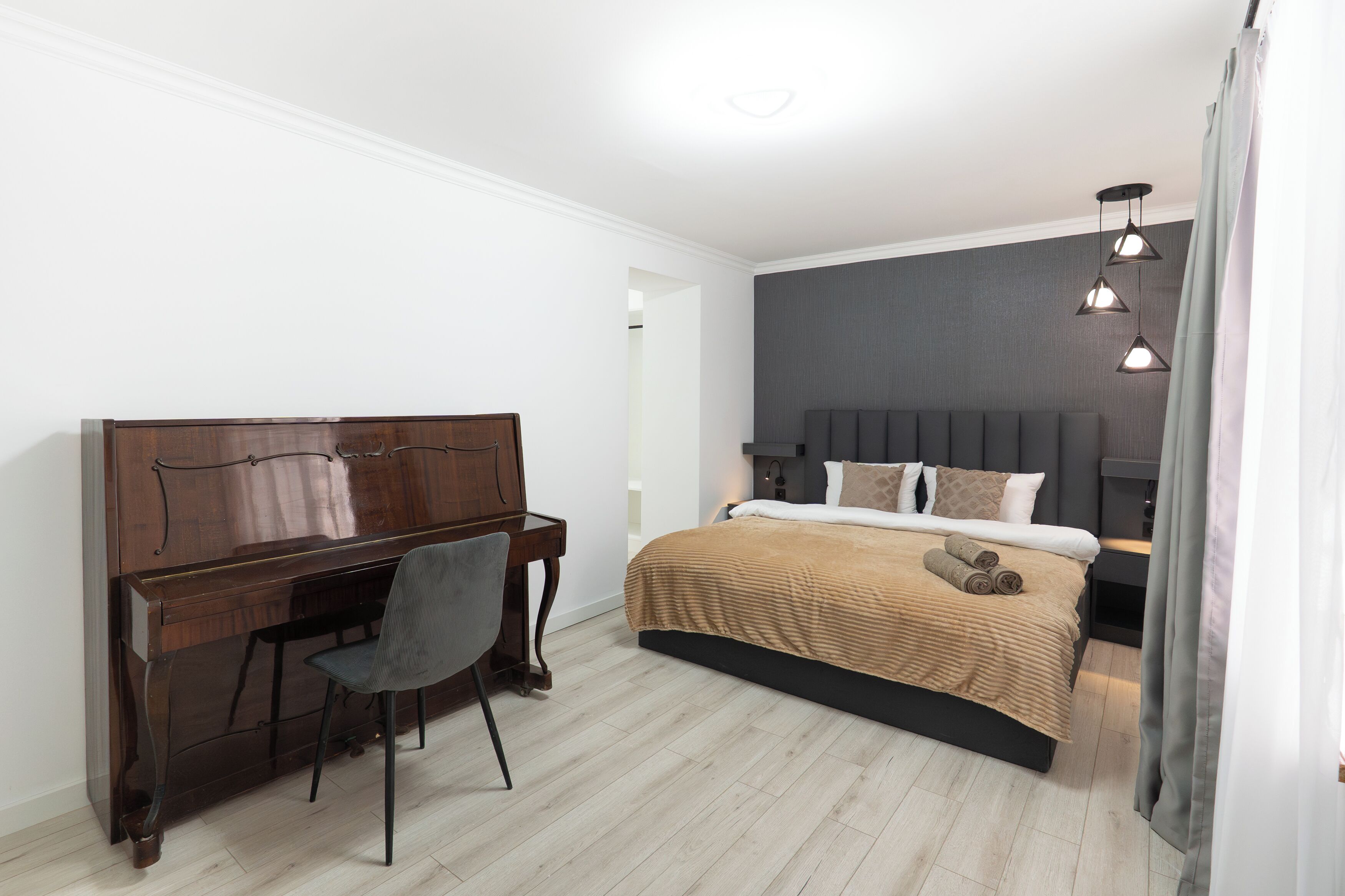A bedroom with a bed, a desk, and a chair.