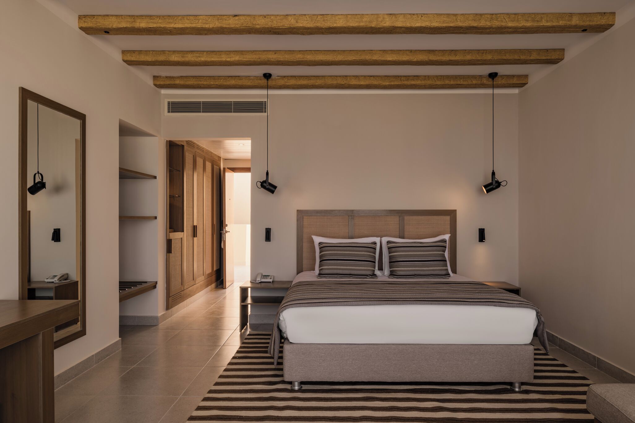 Unwind in a serene king bed under warm wood beams.