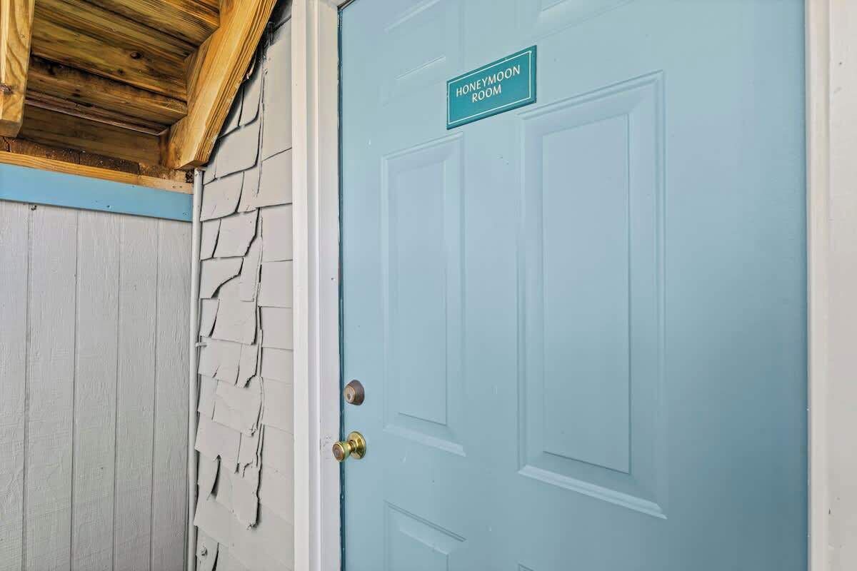 Una puerta azul claro con un letrero que dice 'Honeymoon Room'.