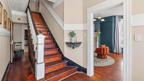 A staircase leading to a landing with a dark wooden finish, a white balustrade, and a small decorative item on the landing. - Pullman Room | Team Joseph Ellen (St. Augustine)