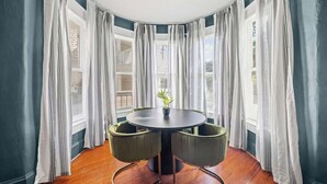 A corner room with a round table, two chairs, and a potted plant. - Pullman Room | Team Joseph Ellen (St. Augustine)