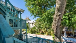 A two-story building with a blue staircase and a tree in the foreground. - Flower Room | Team Joseph Ellen (St. Augustine)