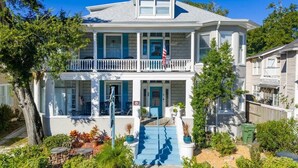 A two-story house with a balcony, a front porch, and a flag. - Flower Room | Team Joseph Ellen (St. Augustine)