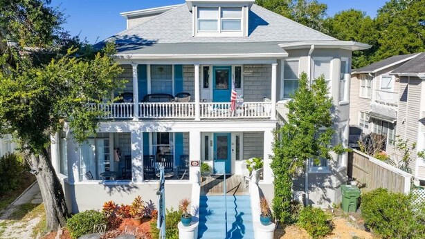 A two-story house with a balcony, a front porch, and a flag. - Crystal Room | Team Joseph Ellen (St. Augustine)
