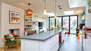 Una cucina moderna con isola centrale, scaffalature aperte e vista sull'esterno.