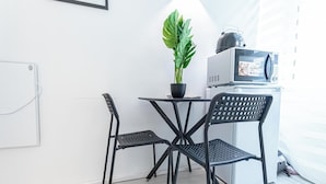 A small kitchenette with a microwave, a kettle, and a potted plant on a table. - Comfy Apt Long Stay Near Praterstern (Vienna)