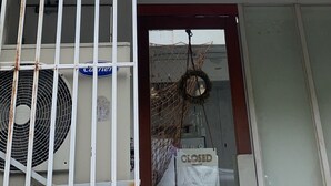 A building with a closed sign, a balcony with a railing, and a large air conditioning unit. - TWH Hostel Bangkok (Bangkok)